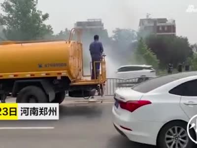 郑州街头汽车自燃 旁边洒水车秒变消防车灭火